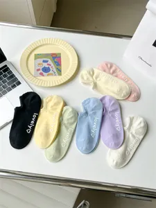 Close-up details of vibrant multi-color combed cotton invisible boat socks with grip.