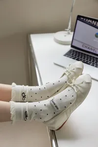 Vista dettagliata di calzini medi da donna in stile balletto con pois e fiocco.