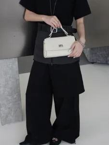 Vue détaillée de l'élégant sac à main en cuir blanc avec fermoir tournant en métal.