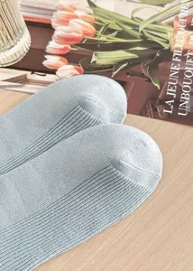 Close up of light grey ribbed cotton socks detail shot, soft texture and fine knit pattern.