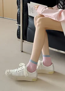 Detailed close-up of stylish contrast cuff mid-tube socks paired with casual canvas sneakers.