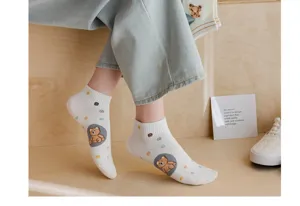 Gros plan sur des chaussettes basses en coton blanc dotées d'une jolie broderie d'ourson.