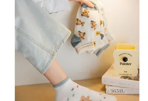 Gros plan sur les chaussettes courtes pour femmes avec motif d'ours mignon en coton doux.