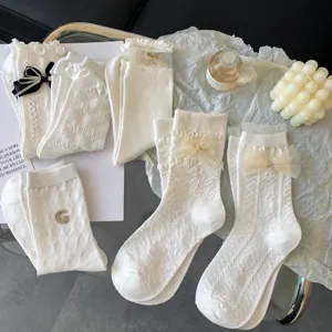 Cute Japanese Lolita white cotton mid-calf socks with sweet lace trim and bows for women.