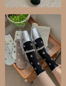 Detailed view of women's breathable mid-calf socks with delicate floral patterns and chic shoes.