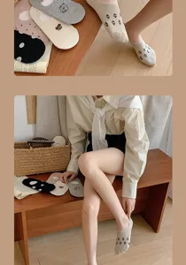 Detail view of cute floral embroidered women invisible boat socks in lifestyle wooden scene setting.