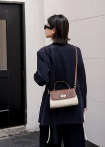 Elegante Damen Zweifarbige Leder Umhängetasche mit Metall-Drehverschluss und Tragegriff.