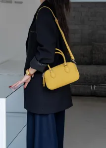 Vue détaillée du mini sac Boston en cuir jaune avec une texture raffinée et de beaux détails.