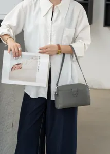 Detailaufnahme der minimalistischen Echtleder Umhängetasche in elegantem Grau mit feiner Textur.