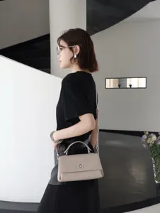 Petit sac bandoulière en cuir élégant avec poignée et fermeture métallique pour un usage quotidien.