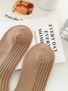 Close up detail of light brown ribbed casual socks, soft cotton knit texture, flat lay.