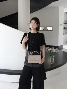 Vue détaillée d'un élégant sac à main en cuir porté dans un bel intérieur moderne.