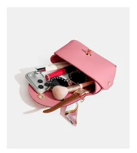 Pink leather handbag interior detail showcasing daily storage capacity, elegant lock clasp design.