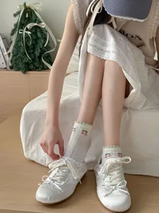 Close-up of sweet pastoral style white short cotton socks with cute cherry embroidery.