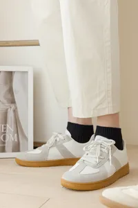 Detailed view of casual short socks paired with stylish lifestyle sneakers in indoor setting.