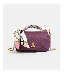 Leather crossbody bag detail with gold chain, turn-lock closure and elegant silk scarf.
