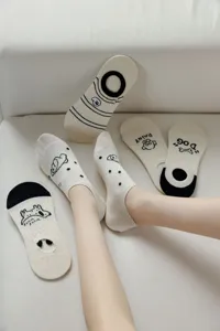 Detail shot of cute beige cotton boat socks featuring lovely dog prints and anti-slip heel.
