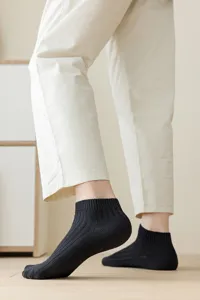 Detail shot of black ribbed low-cut ankle socks for men and women, breathable cotton.