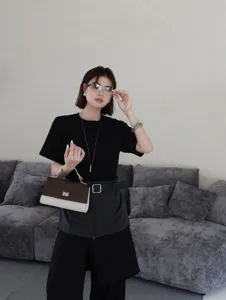 Vue détaillée du sac à main en cuir élégant avec couleur contrastée et serrure en métal.