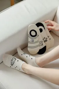 Close-up detail view of cute beige cotton invisible boat socks with lovely puppy prints.