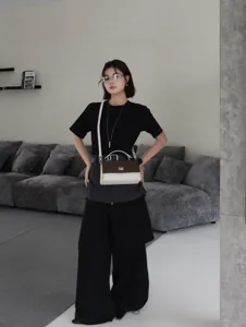 Sac à bandoulière élégant en cuir véritable avec poignée supérieure et fermoir métallique.