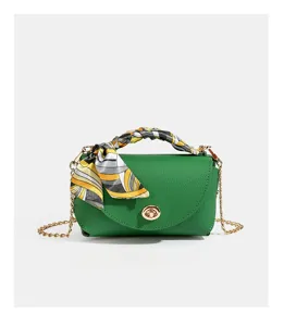 Green leather shoulder bag with gold chain strap, twist lock closure and printed silk scarf.