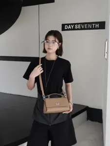 Vue de detail du sac a bandouliere elegante en cuir avec serrure metallique chic.