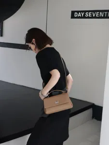 Sac à bandoulière minimaliste en cuir beige pour femme, détail de sac élégant chic.