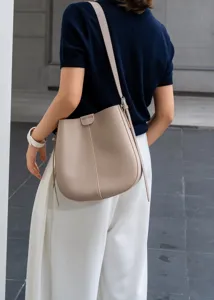 Detail view of a stylish leather bucket bag worn on shoulder, versatile and perfect for daily commute.
