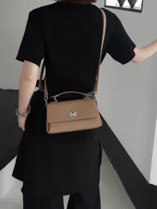 Vue détaillée du sac bandoulière en cuir kaki stylé porté par le modèle, belle qualité.
