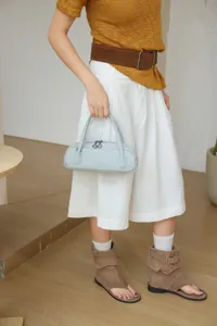 Close-up view of light blue leather handbag, elegant minimalist fashion style.