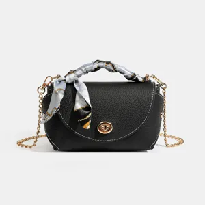 Black leather crossbody bag with chain strap, turn-lock closure and elegant silk scarf handle.