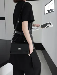 Sac bandoulière en cuir noir pour femme, élégant sac à main avec serrure en métal et poignée.