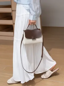 Two-tone leather shoulder bag featuring a brown flap, top handle, and elegant daily commuter style.