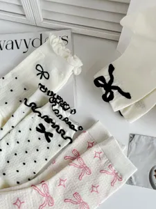 Vista dettagliata di calzini medi in stile balletto dolce con fiocchi neri e pois graziosi.