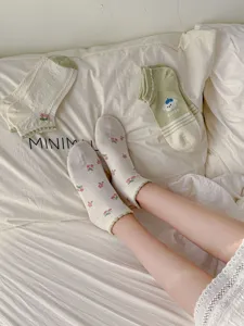 Detailed view of floral cotton socks, pastoral style green and white short socks.