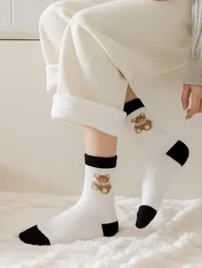 Detail view of thick warm wool socks with cute bear embroidery and contrast color design.