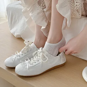 Gros plan sur des socquettes fines et respirantes en maille associées à des baskets.