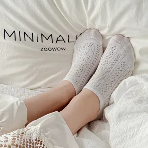 Gros plan de chaussettes courtes d'été respirantes en maille pour femme, blanc uni, confortable.