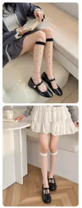 Detail shot of sheer polka dot calf socks paired with black Mary Jane shoes, stylish and breathable.