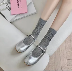 Grey ribbed mid-calf socks paired with silver Mary Jane shoes, elegant detail shot.