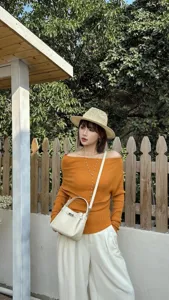 Detailed view of the mini leather Kelly bag showcased in a stylish outdoor outfit.