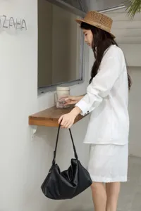 Dettaglio di una borsa hobo in morbida pelle nera, che mostra il suo design casual.
