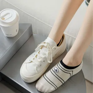 Cute beige cotton boat socks with dog embroidery paired with white canvas shoes for women spring summer.