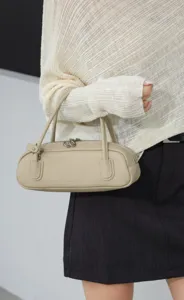 Close-up detail of beige leather underarm bag, elegant minimalist design for daily wear.