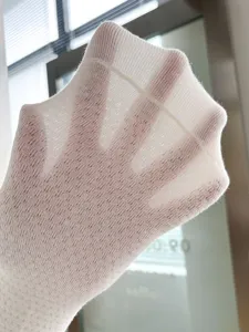 Primo piano dettagliato di calzini bianchi in rete traspirante con trama a maglia fine.
