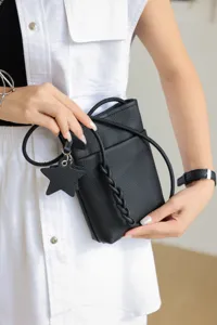 Genuine leather mini crossbody phone bag with star charm and chic braided strap detail.