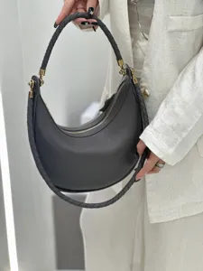 Detailansicht der dunkelgrauen Schultertasche aus Leder mit stilvollem geflochtenem Griff.