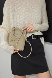 Detailed view of genuine leather mini crossbody bag with stylish star charm and braided handle.