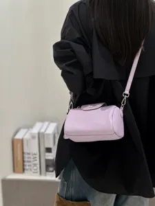 Lila Leder Zylinder Umhängetasche für Damen, stilvolle Crossbody Handtasche mit Gurt.